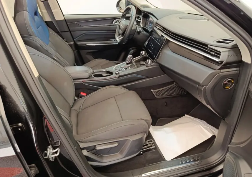 Intérieur avant droit du Lynk & Co 01 hybride rechargeable 2022, sièges noirs et tableau de bord moderne avec écran tactile.