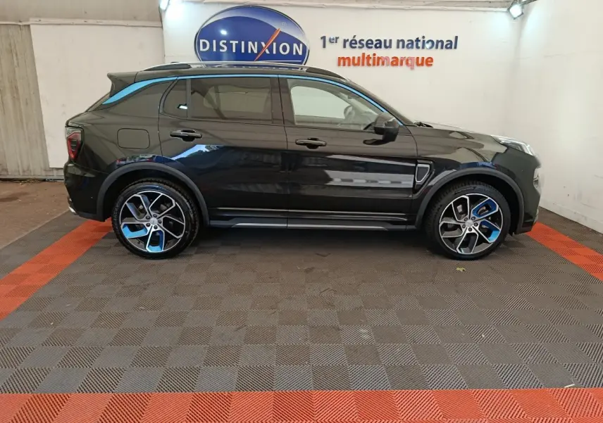 Vue latérale droite d'un SUV Link & Co 01 hybride rechargeable bleu foncé avec jantes bicolores et toit noir.