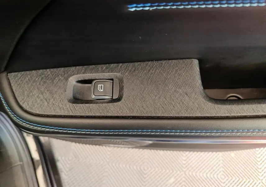 Détail de la commande de lève-vitre sur la portière intérieure avec surpiqûres bleues du LINK & CO 01 Hybride rechargeable.