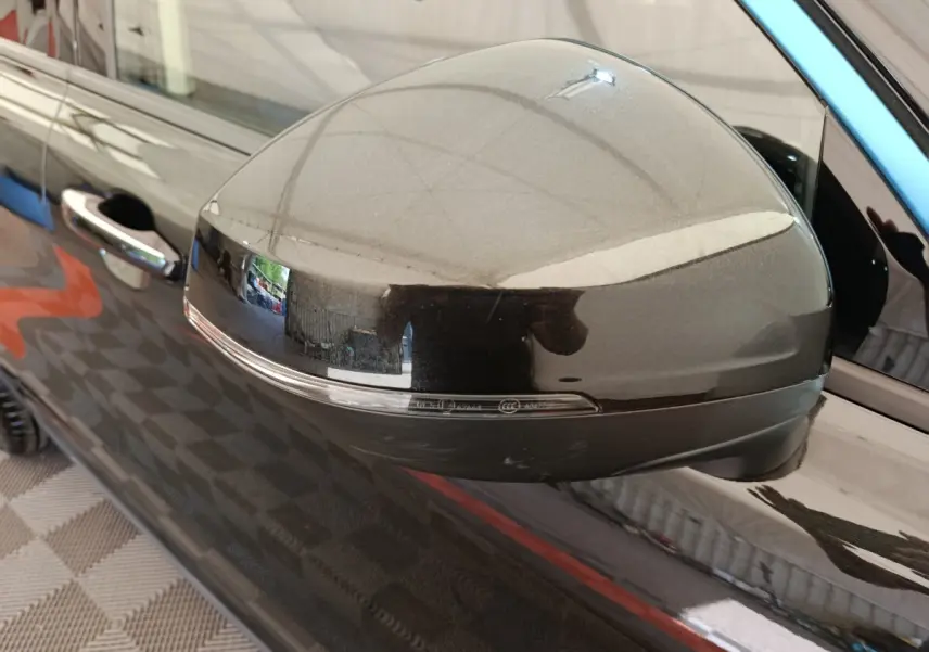 Gros plan sur le rétroviseur droit noir brillant du SUV bleu LINK & CO 01 hybride rechargeable 2022.