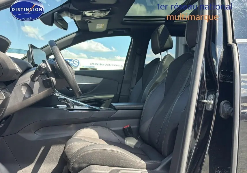 Intérieur noir du Peugeot 5008 2022, vue côté conducteur avec sièges cuir et toit ouvrant panoramique visible.