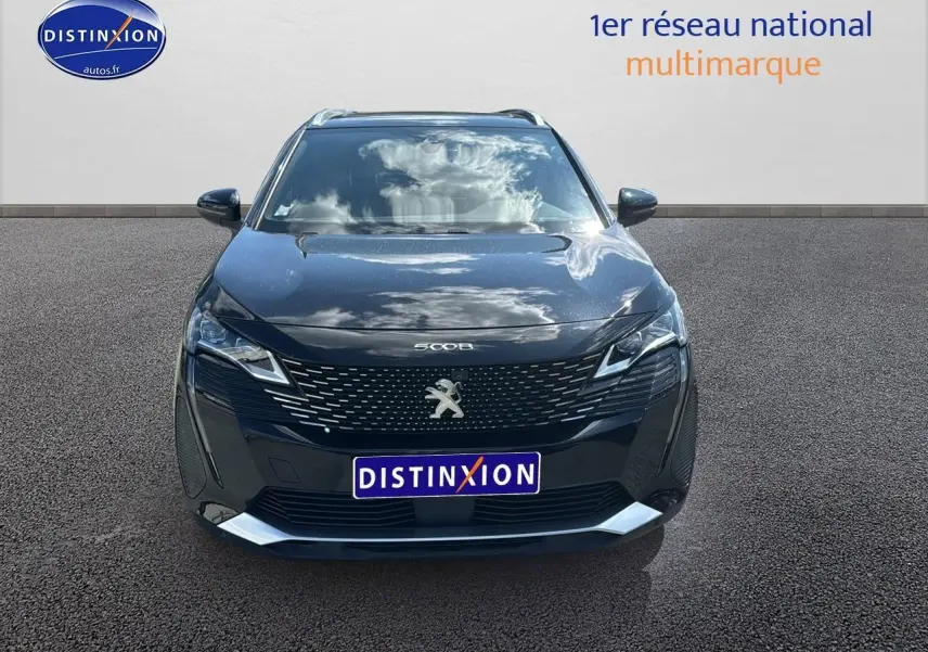 Peugeot 5008 noir métal vue de face avec calandre distinctive et phares LED allumés.