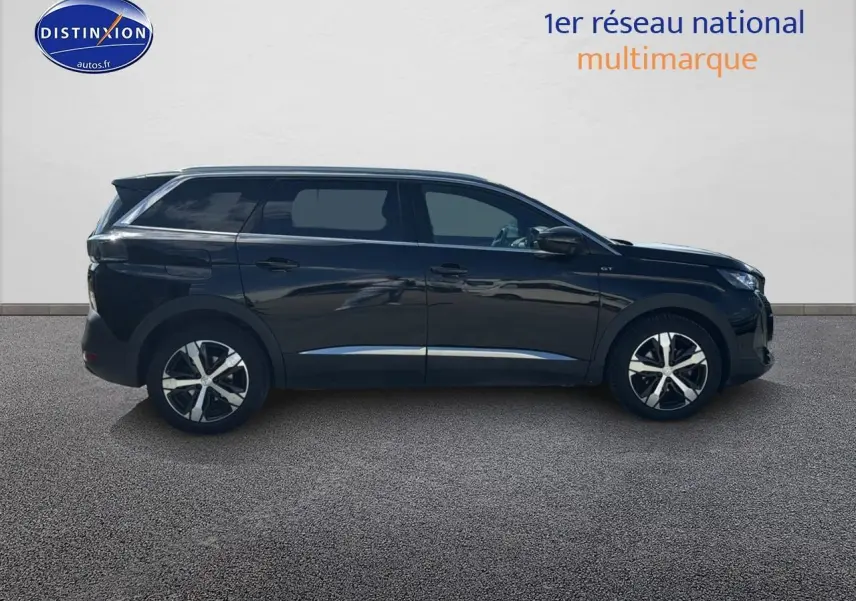 Profil côté gauche du Peugeot 5008 noir métal 2022 avec jantes alliage et barres de toit visibles.