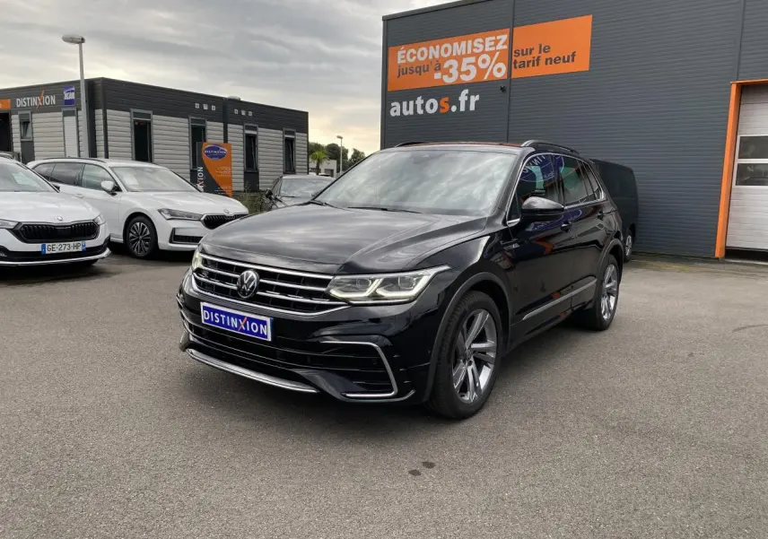 Volkswagen Tiguan noir intense métallisé en 3/4 avant droit avec jantes alliage et projecteurs Matrix LED allumés.