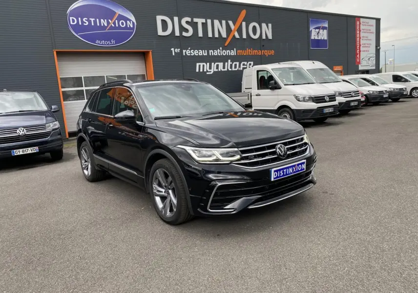Volkswagen Tiguan noir intense métallisé en 3/4 avant avec jantes alliage et projecteurs LED Matrix allumés.