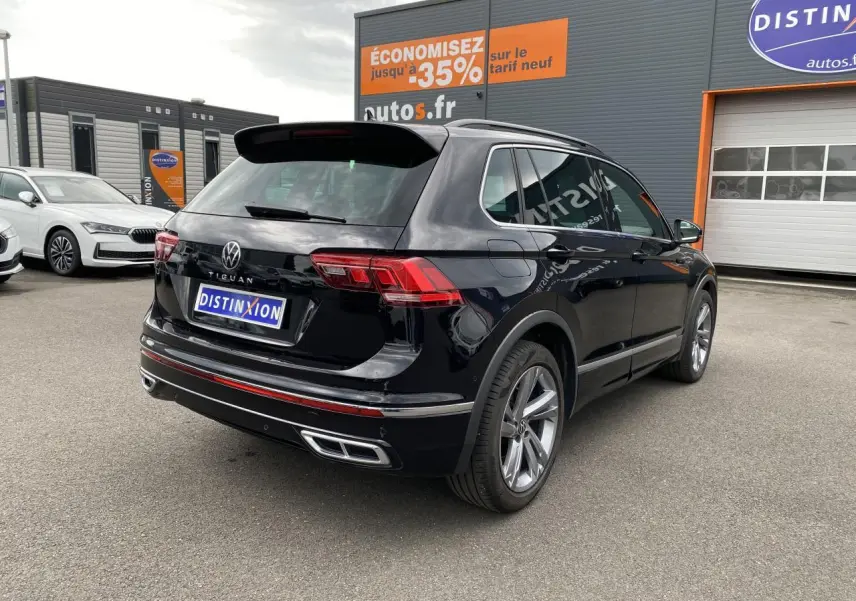 Vue 3/4 arrière droite d'un Volkswagen Tiguan noir intense métallisé avec finition R-Line et jantes alliage 19 pouces.