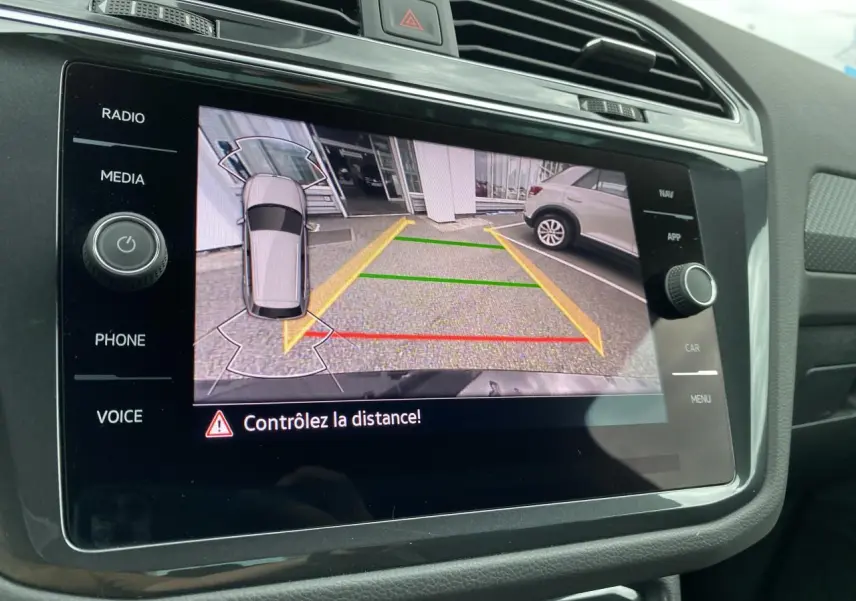 Écran tactile du tableau de bord du Volkswagen Tiguan 2023 montrant la caméra de recul avec guidage de stationnement.