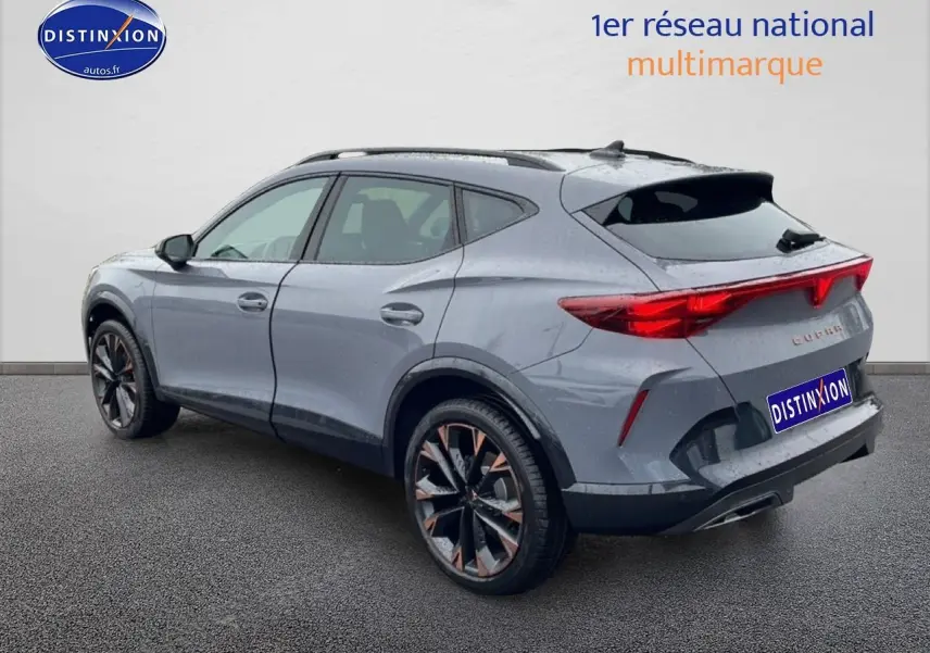 Vue 3/4 arrière droite d'un CUPRA Formentor gris graphene avec jantes bicolores et feux arrière LED étirés.