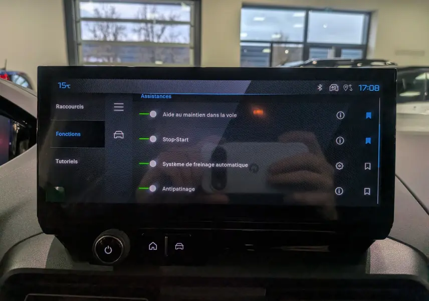 Écran tactile central du Peugeot Rifter 2025 affichant les assistances à la conduite, intérieur en ambiance claire.
