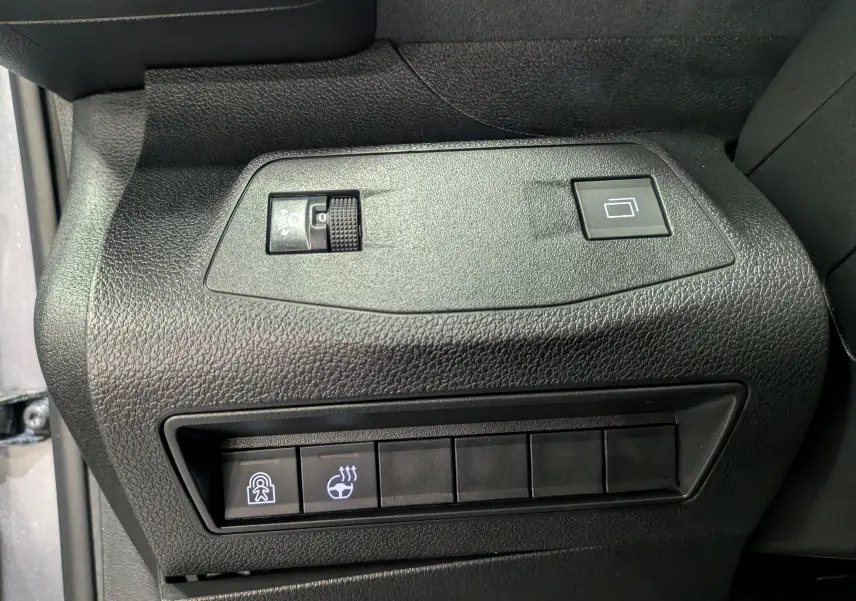 Gros plan sur les commandes noires du tableau de bord côté conducteur du Peugeot Rifter gris acier 2025.