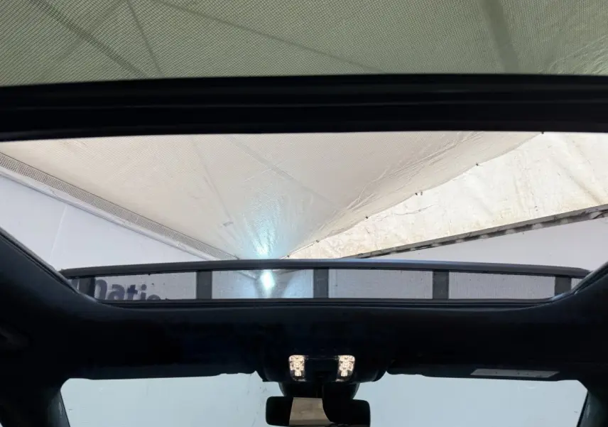 Vue intérieure du toit ouvrant panoramique du Mercedes GLA 250 e AMG Line gris clair, avec éclairage intérieur allumé.