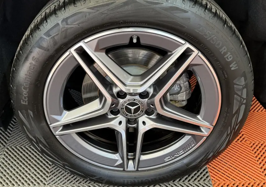 Gros plan sur la jante AMG gris foncé et argentée avec logo Mercedes au centre, montée sur pneu Continental.