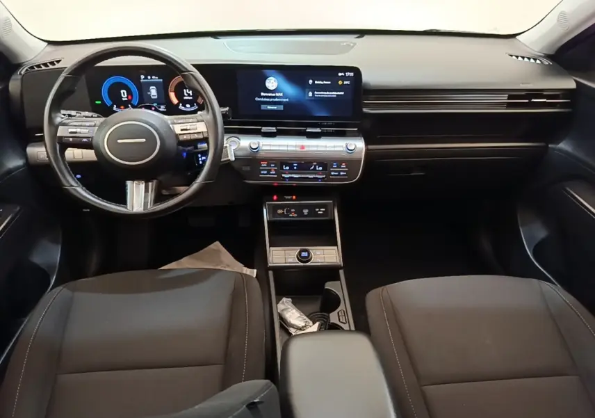 Vue intérieure avant du tableau de bord et volant cuir noir du Hyundai Kona 1.6 Hybrid 2024, avec écran tactile central.