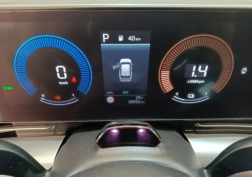 Tableau de bord numérique du Hyundai Kona 2024, affichage vitesse, régime moteur et porte ouverte côté gauche.
