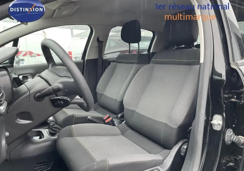 Vue intérieure côté conducteur de la Citroën C3 2023 noire métal, sièges tissu gris et noir avec surpiqûres jaunes.
