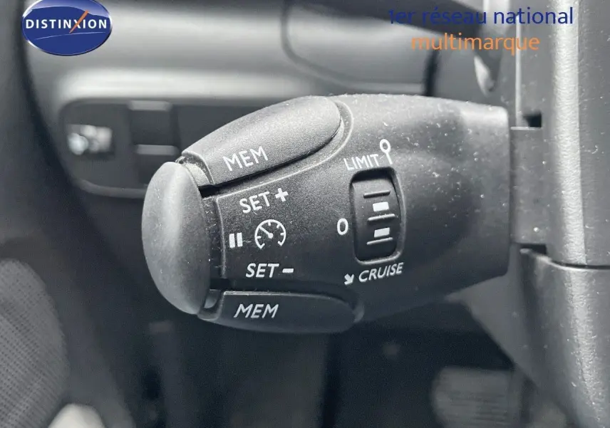 Gros plan sur la commande de régulateur de vitesse du Citroën C3 noir métal 2023, côté volant à gauche.