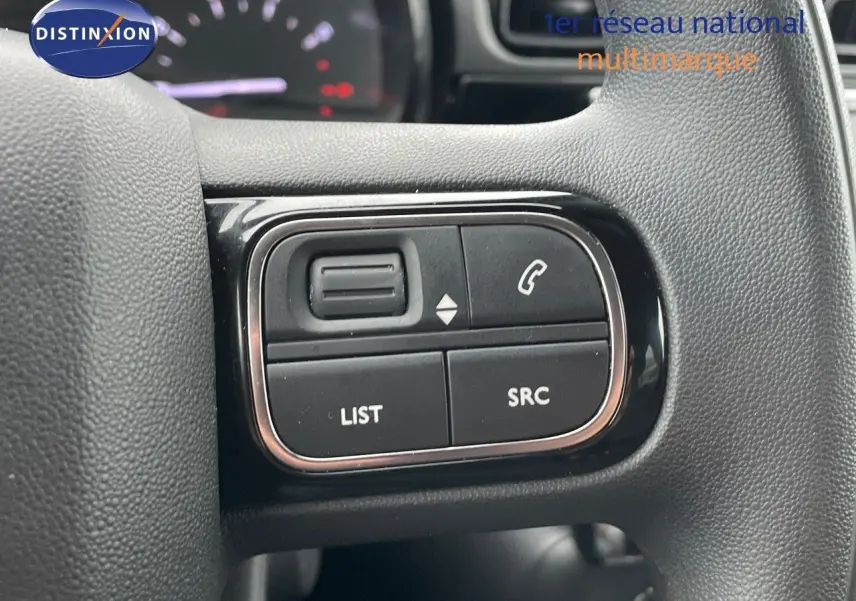 Gros plan sur les commandes au volant du côté gauche du Citroën C3 noir métal 2023, version Shine.