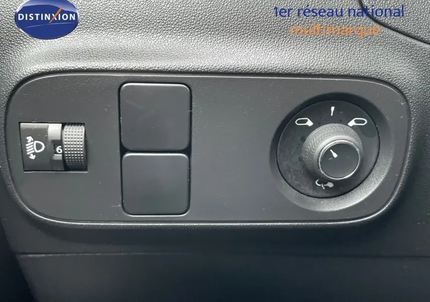 Commande de réglage des phares et des rétroviseurs sur le tableau de bord intérieur d'une Citroën C3 noire métallisée 2023.