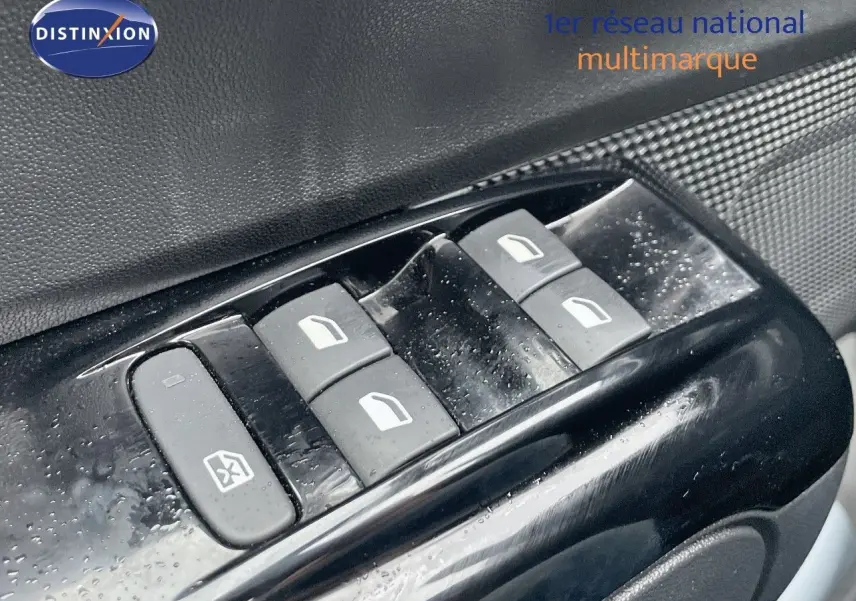 Gros plan sur les commandes de lève-vitres côté conducteur d'une Citroën C3 noire métal 2023.