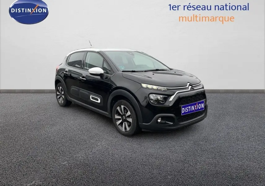 Citroën C3 noire métal vue 3/4 avant droit avec coques de rétroviseurs blanches et jantes bi-ton.