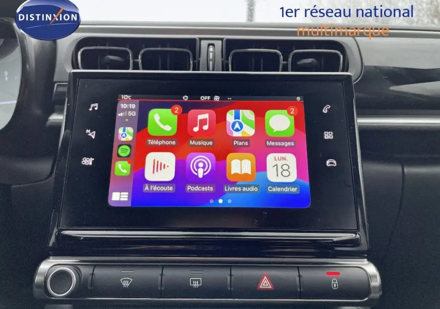 Écran tactile central allumé dans l'habitacle d'une Citroën C3 noire métal 2023, avec interface Apple CarPlay visible.