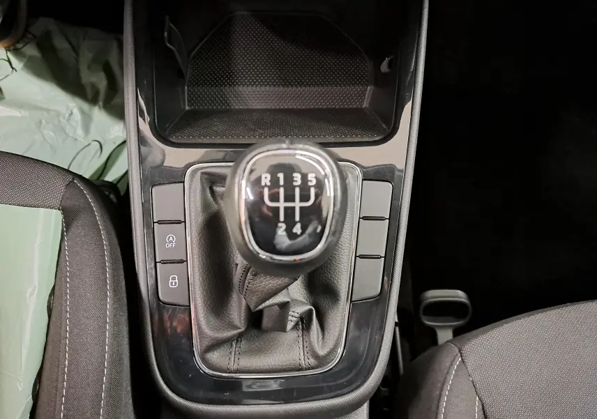 Vue rapprochée du levier de vitesses manuel de la Skoda Fabia 2023 avec console noire et sièges gris.