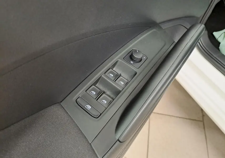 Commande des vitres électriques et réglage des rétroviseurs sur la portière côté conducteur d'une Skoda Fabia blanc candy 2023.