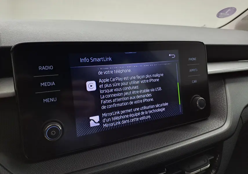 Écran tactile central de la Skoda Fabia 2023 affichant les options Apple CarPlay et MirrorLink, intérieur noir.