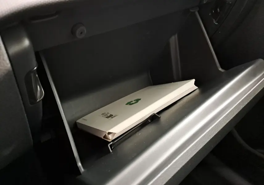 Gros plan sur la boîte à gants ouverte d'une Skoda Fabia 2023, avec un manuel blanc à l'intérieur.
