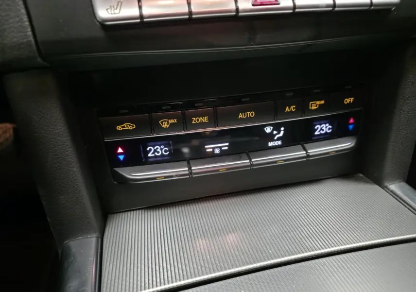Détail de la console centrale avec commandes de climatisation affichant 23°C sur Mercedes Classe E noire 2015.