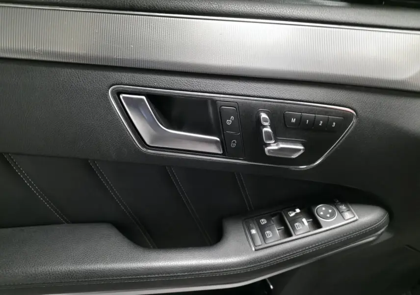 Gros plan sur la garniture intérieure noire côté gauche de la porte avant d'une Mercedes Classe E E 300 BlueTEC Hybrid 2015.