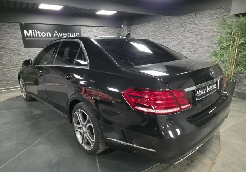 Vue 3/4 arrière droite d'une Mercedes Classe E noire avec jantes alliage 5 branches doubles et feux arrière LED.