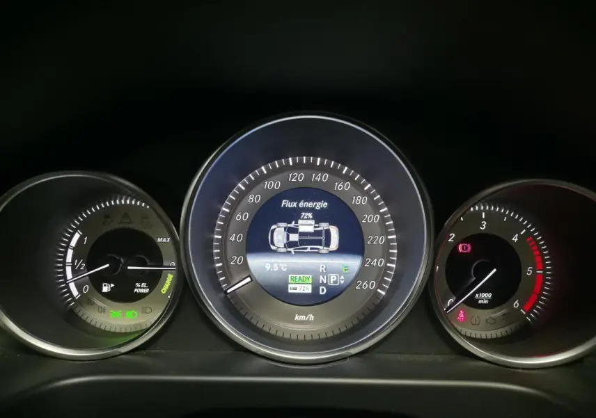 Tableau de bord de Mercedes Classe E 300 BlueTEC Hybrid 2015 avec affichage numérique du flux d'énergie et compte-tours.