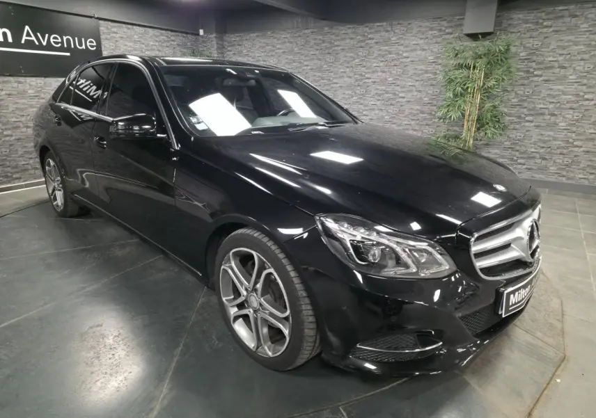 Mercedes Classe E 300 BlueTEC Hybrid noire vue en 3/4 avant avec jantes alliage 18 pouces et calandre à deux lamelles.