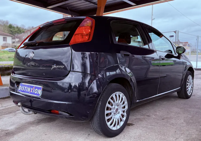 Vue 3/4 arrière droite d'une Fiat Punto noire de 2009 avec attelage et jantes multibranches argentées.