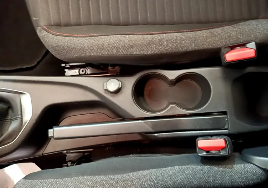 Vue rapprochée de la console centrale avec frein à main manuel et porte-gobelets du Peugeot 2008 blanc 2021.