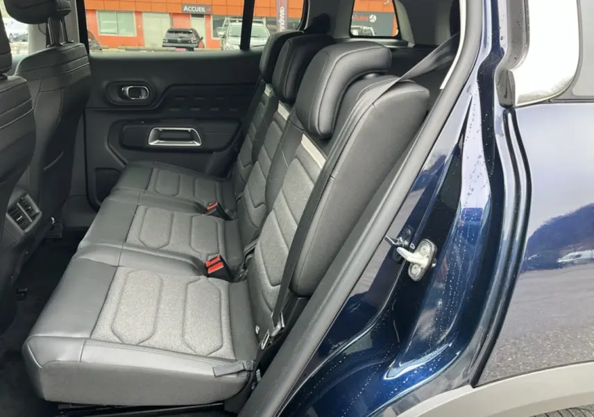 Vue latérale intérieure montrant les trois sièges arrière individuels en tissu gris du Citroën C5 Aircross Hybrid Eclipse Blue.