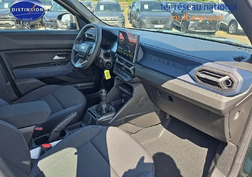 Vue intérieure côté conducteur du Dacia Duster 2025 avec tableau de bord moderne et volant multifonction.