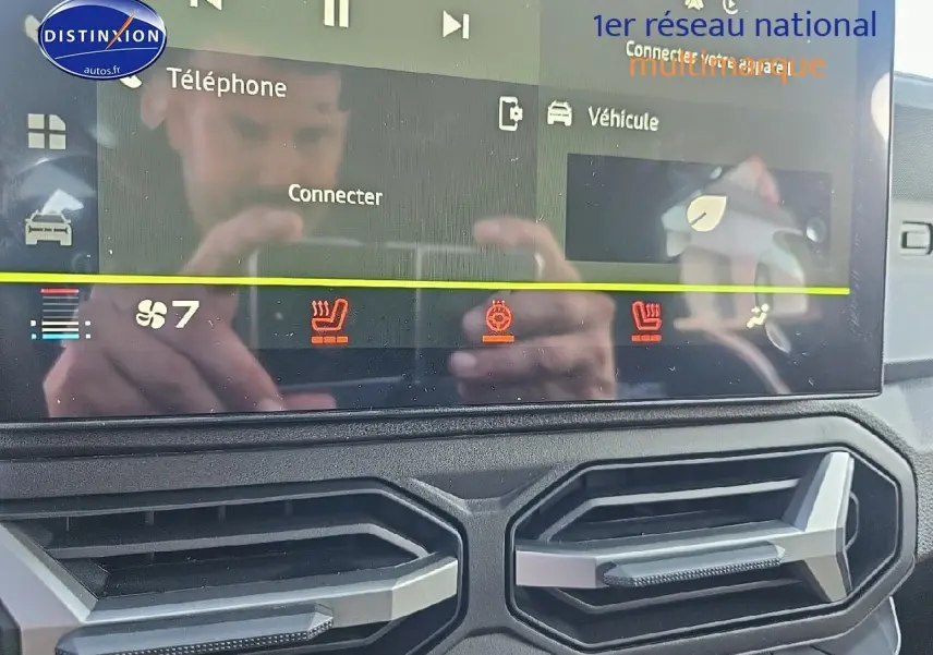 Gros plan sur l'écran tactile et les aérateurs du tableau de bord du Dacia Duster 2025, intérieur noir.