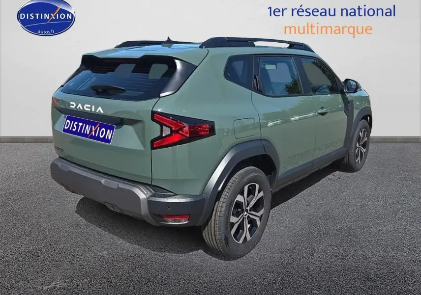 Vue 3/4 arrière droite d'un Dacia Duster vert kaki avec jantes alu et barres de toit noires.
