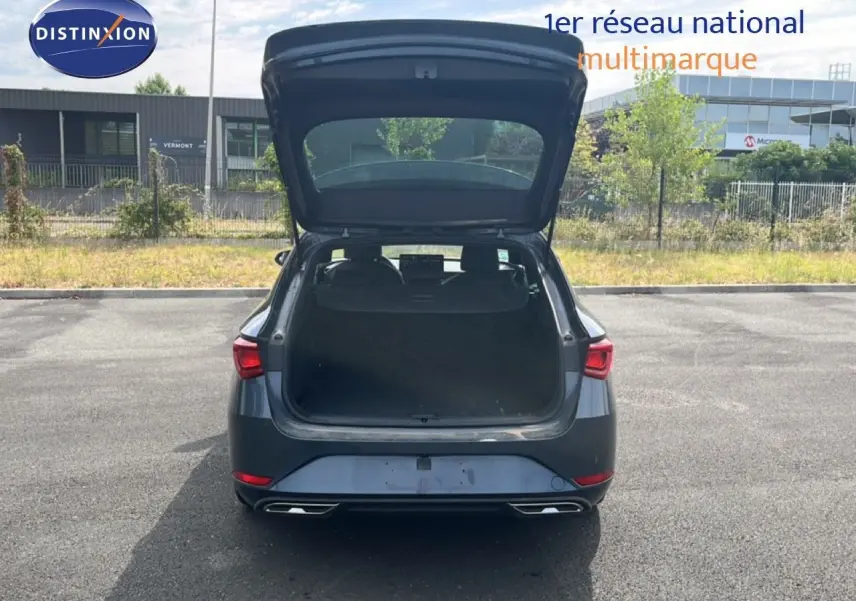 Vue arrière d’une SEAT LEON ST gris magnétique métal 2025 avec coffre ouvert sur un parking extérieur.
