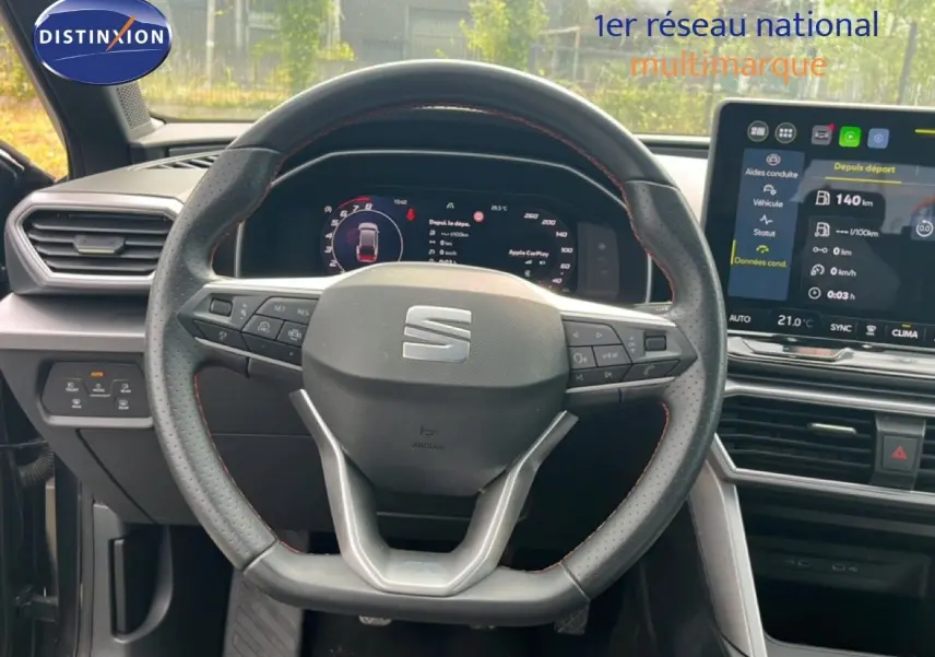 Vue intérieure centrée sur le volant perforé et le tableau de bord numérique du SEAT LEON ST gris métallique.