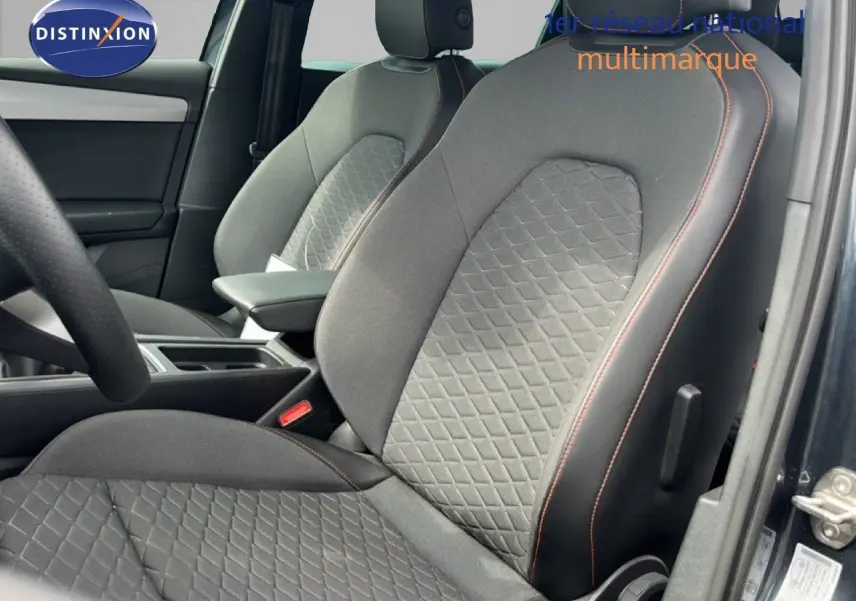 Vue intérieure rapprochée des sièges avant gris noir avec surpiqûres orange d’un SEAT LEON ST 2025 gris magnétique.