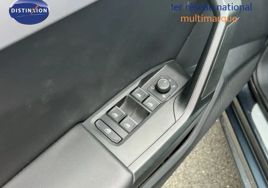 Détail de la commande des vitres électriques et réglage des rétroviseurs sur la porte côté conducteur d’une SEAT LEON ST gris magnétique.