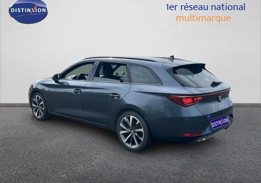SEAT Leon ST gris magnétique métal vue 3/4 arrière droit, avec jantes alliage et feux arrière LED allumés.