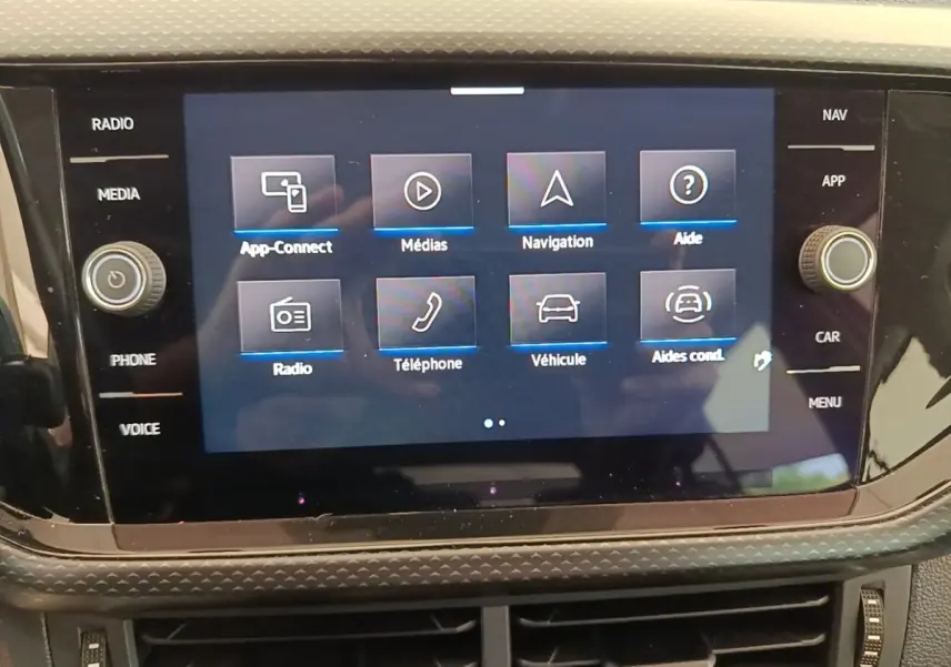Écran tactile central du tableau de bord du Volkswagen T-Cross blanc, affichant le menu principal multimédia.