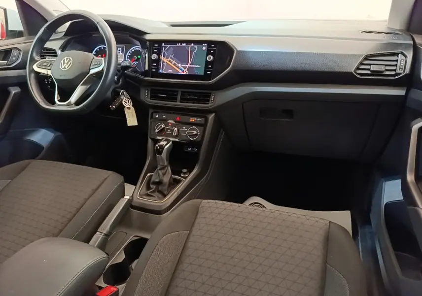 Vue intérieure avant du Volkswagen T-Cross 2022, tableau de bord noir avec écran tactile et volant multifonctions cuir.