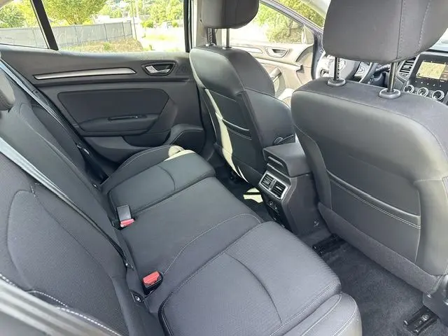 Vue intérieure arrière de la Renault Mégane 1.5 Blue dCi 115ch Business 2021, sièges noirs et console centrale avec aérateurs.