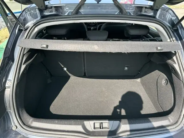 Coffre ouvert de la Renault Mégane bleu 2021, vue arrière montrant l’espace de chargement et la plage arrière.