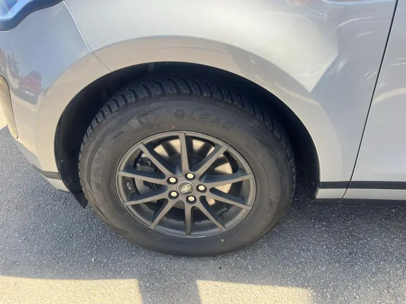 Gros plan sur la roue avant gauche du Range Rover Evoque Indus Silver avec jante alu noire et pneu visible.